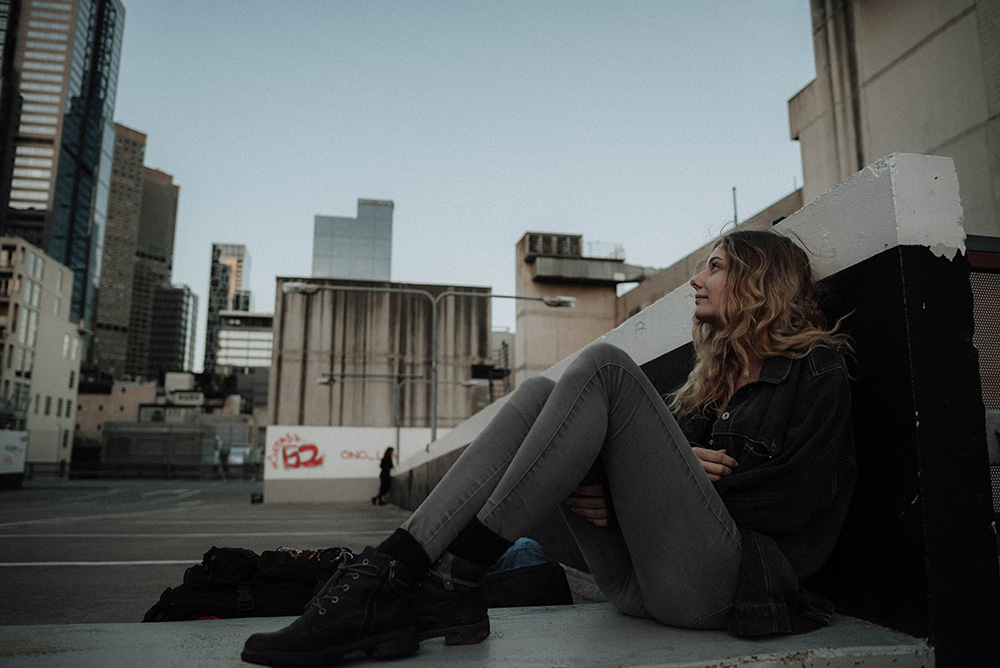 Female teen child sitting and looking over a city.